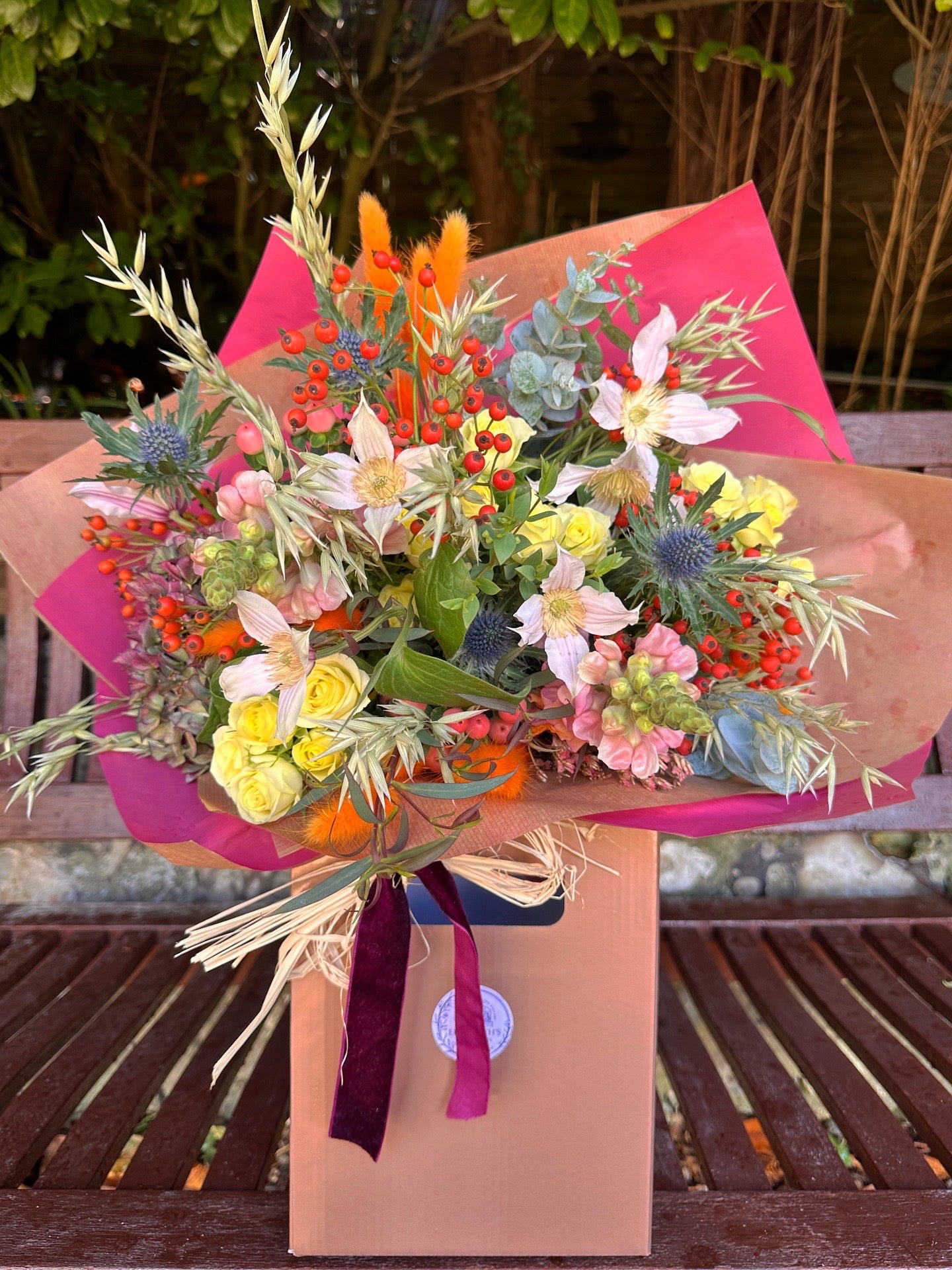 Colourful bouquet in Autumn tones of red, pink, orange with a rustic wild feel