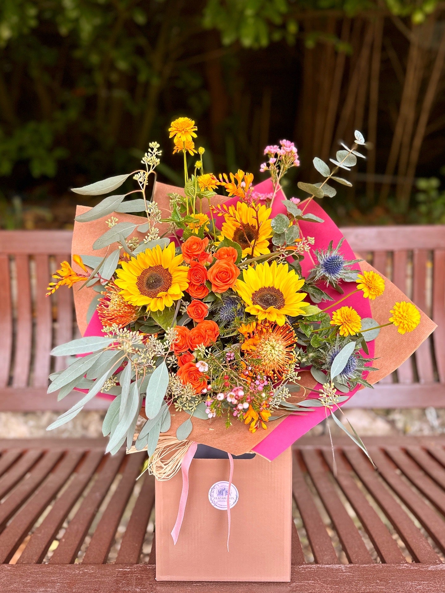 Floral bouquet in tones of orange, yellows and blues. Natural country garden style.