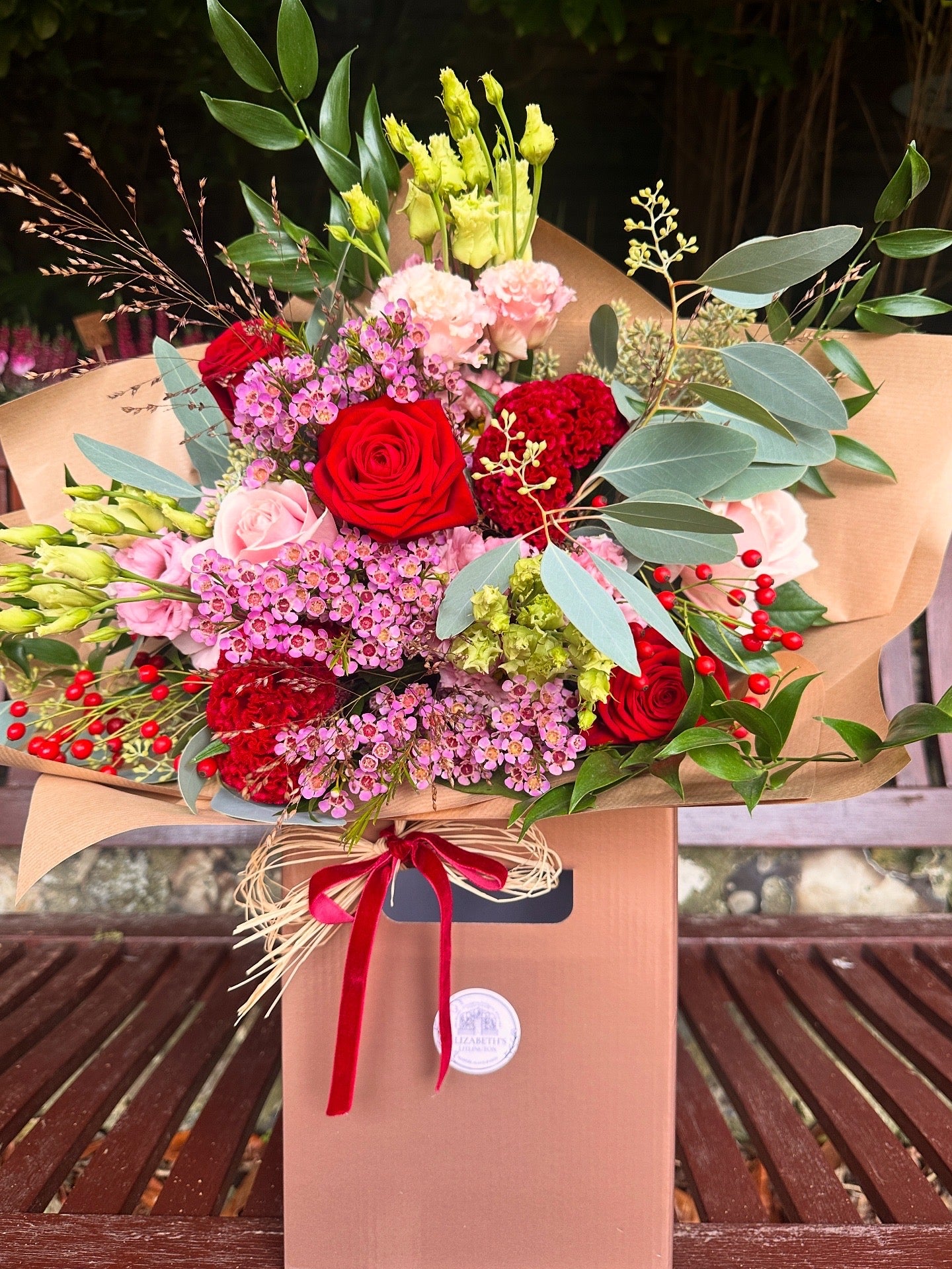 Bouquet of red and pink flowers with greenery Roses included 