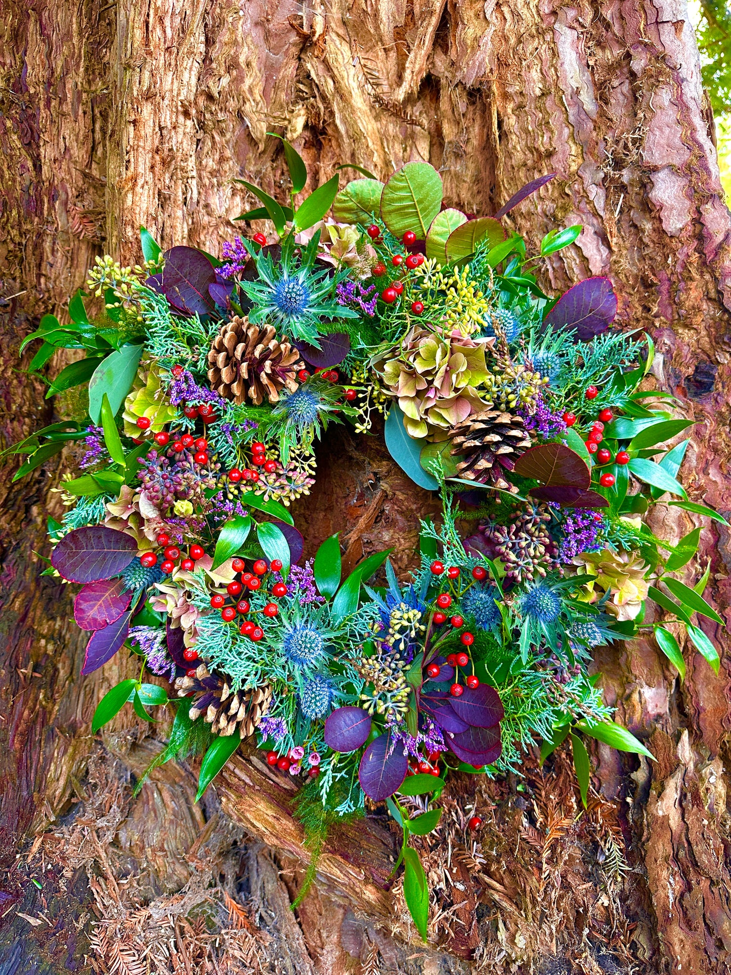 Decorative wreath with greenery, berries, and pinecones natural look