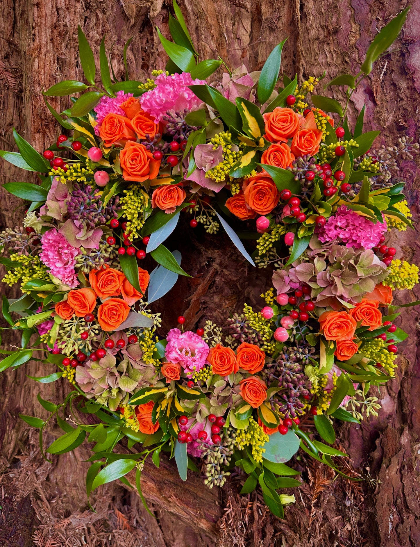 Colourful floral wreath with orange, pink, and green foliage